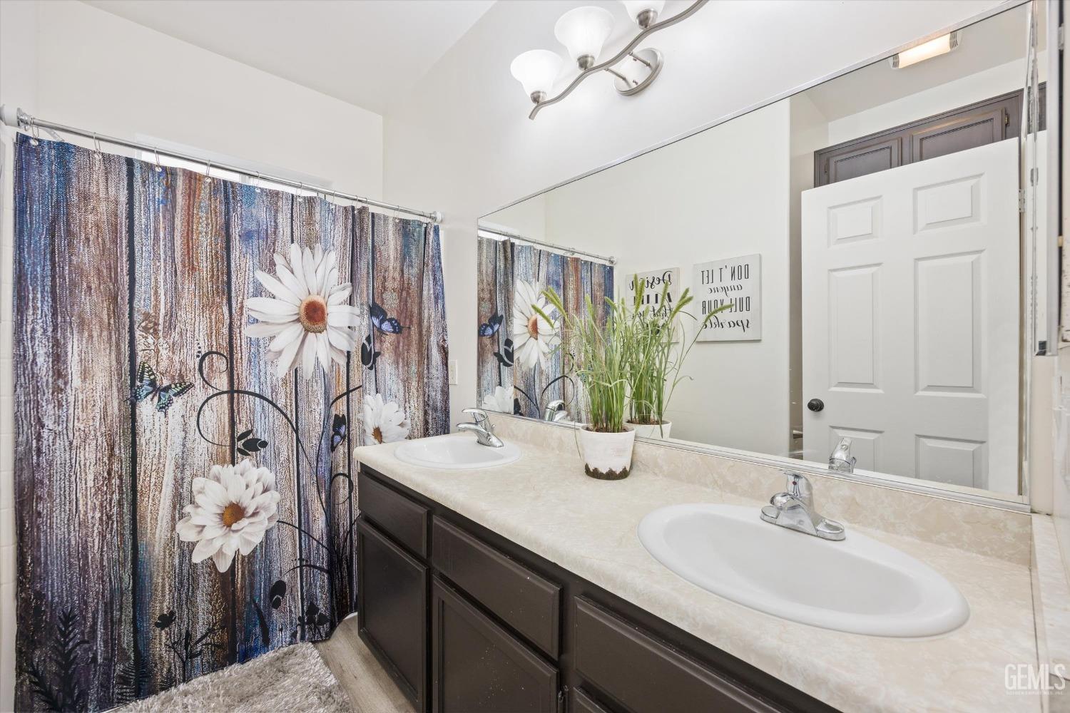 Undisclosed Address Bakersfield, CA 93307 - Photo 25 of 35 a bathroom with a double vanity sink and a mirror