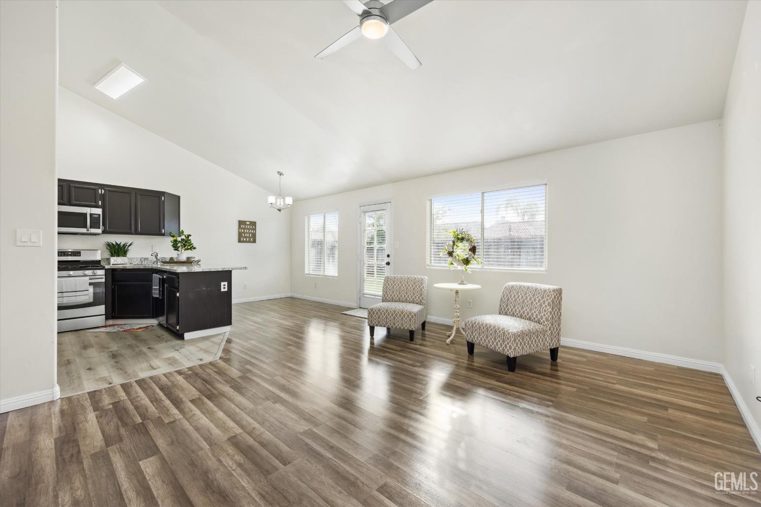Undisclosed Address Bakersfield, CA 93307 - Photo 5 of 35 a living room with couches and kitchen view with wooden floor