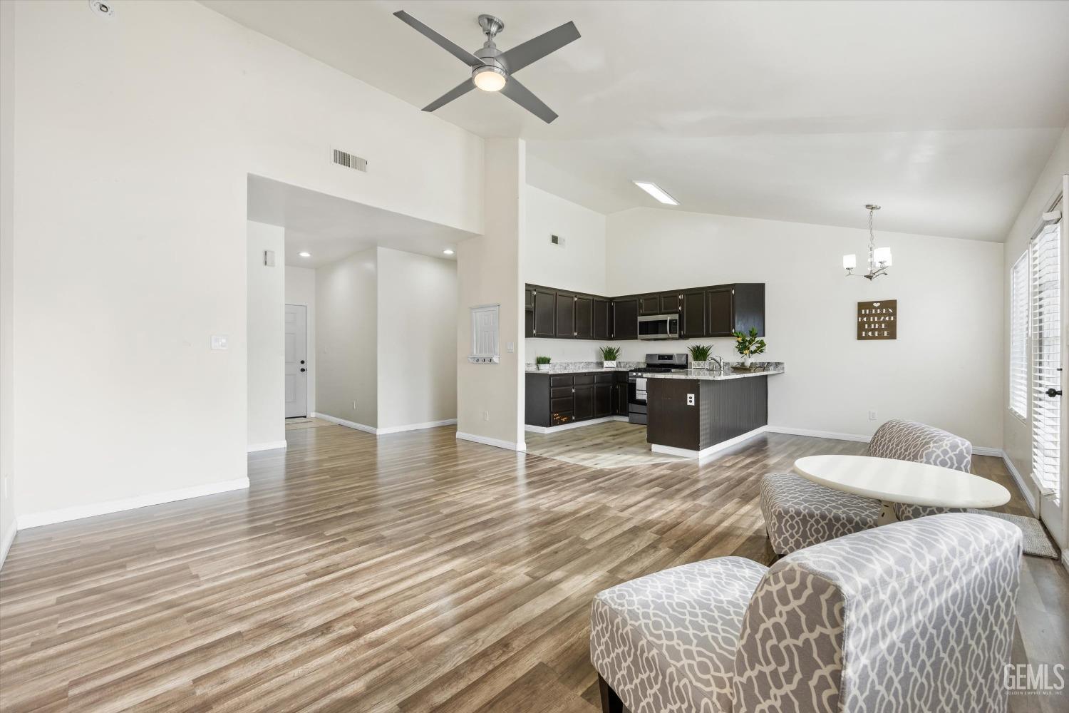 Undisclosed Address Bakersfield, CA 93307 - Photo 9 of 35 a large bedroom with kitchen island a sink wooden floor and stainless steel appliances