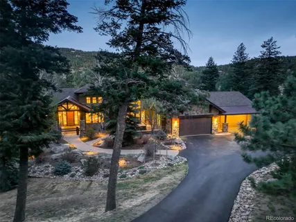 a front view of a house with a yard and tree s