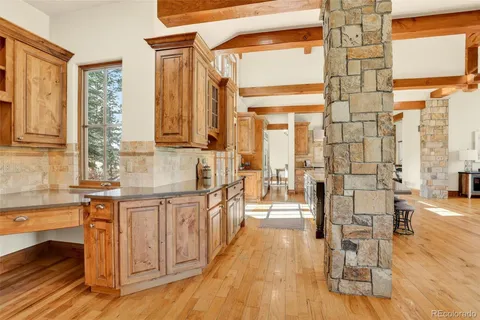 a open kitchen with stainless steel appliances granite countertop a stove and a wooden floors
