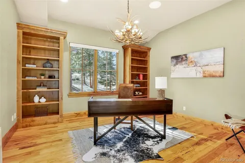 a view of a workspace with furniture and a window