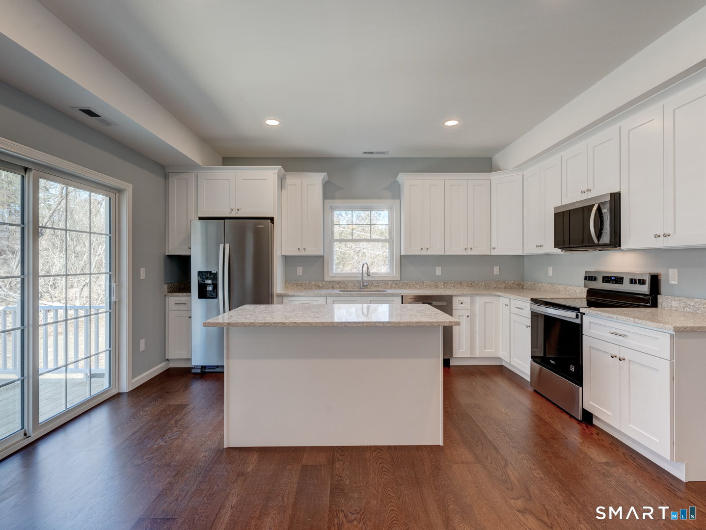 28 Goodell Road Stafford, CT 06076 - Photo 12 of 40 a large kitchen with stainless steel appliances granite countertop a stove a sink dishwasher a refrigerator and a microwave oven with wooden floor