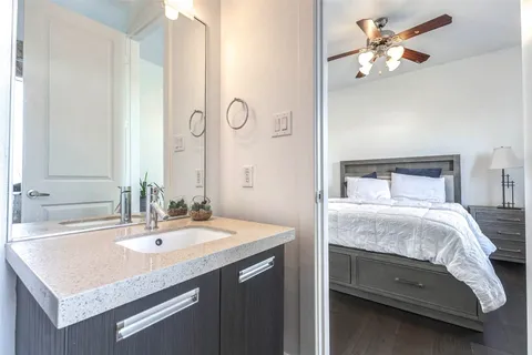 a bedroom with a sink and a mirror