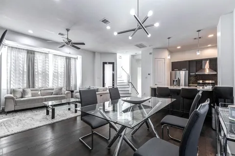 a living room with furniture kitchen area and a large window