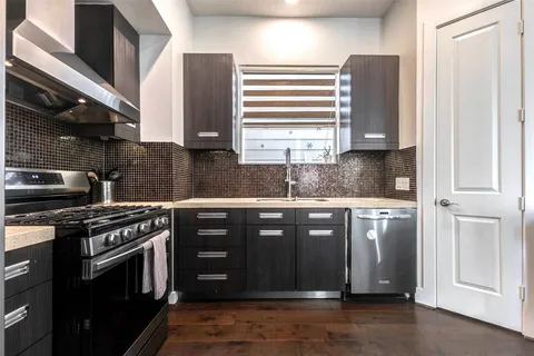 a kitchen with stainless steel appliances granite countertop a stove a sink and a microwave
