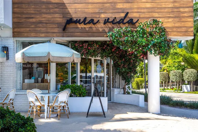 a patio with a table and chairs and potted plants