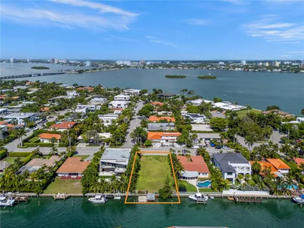 an aerial view of residential houses with outdoor space and lake view