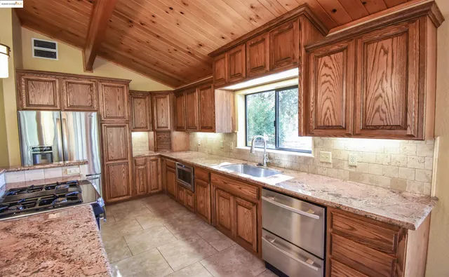 a kitchen with stainless steel appliances granite countertop a sink stove and cabinets