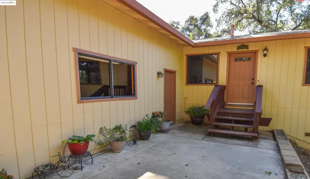 a view of a house with backyard and wooden fence