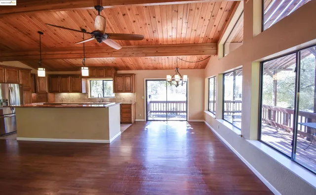 a view of a kitchen with refrigerator and wooden floor