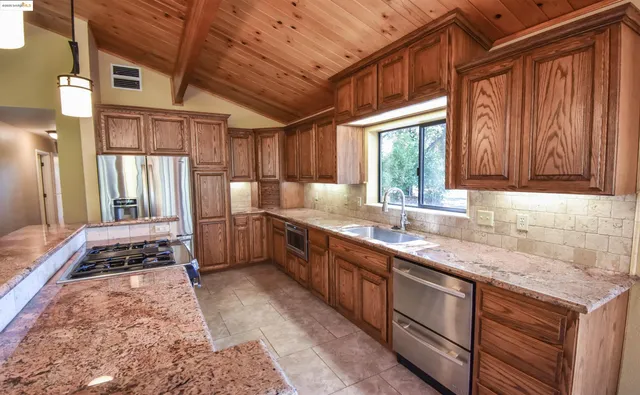 a kitchen with stainless steel appliances granite countertop a sink stove and cabinets