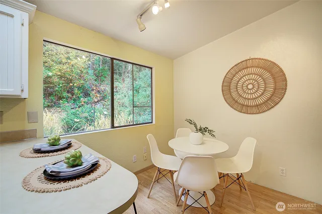 a dining room with furniture a large window and a potted plant