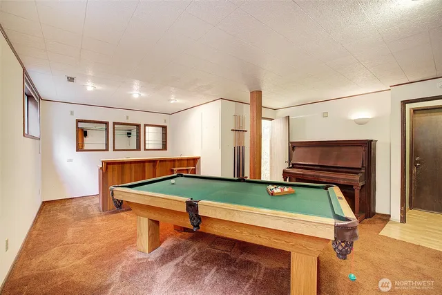 a room with furniture pool table and windows