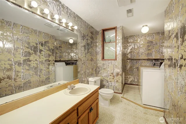 a bathroom with a sink a toilet a mirror and shower