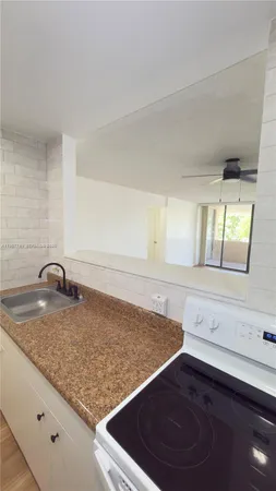 a kitchen with a sink a stove and granite top