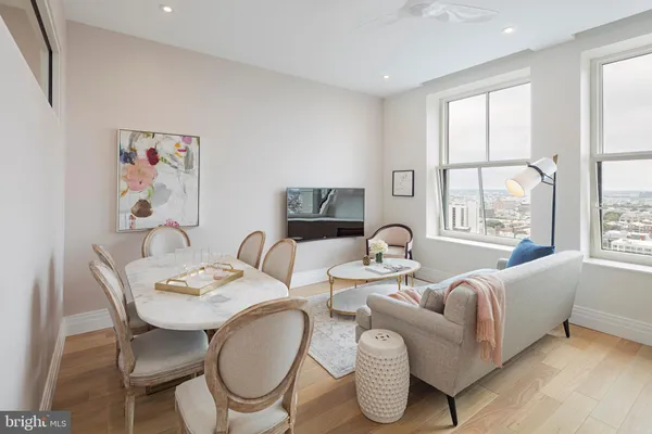 a dining room with furniture a large window and wooden floor