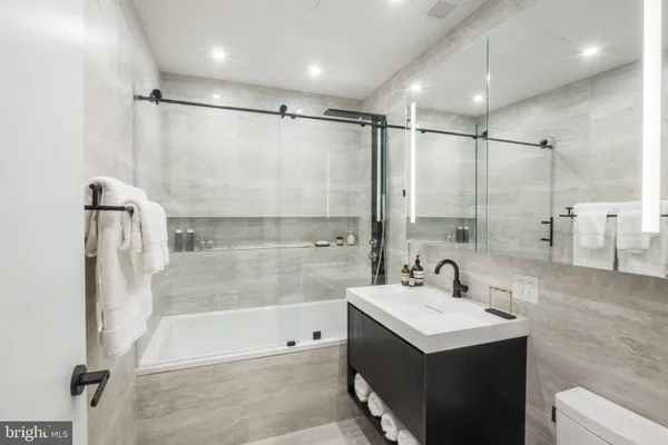 a bathroom with a sink mirror toilet and bathtub