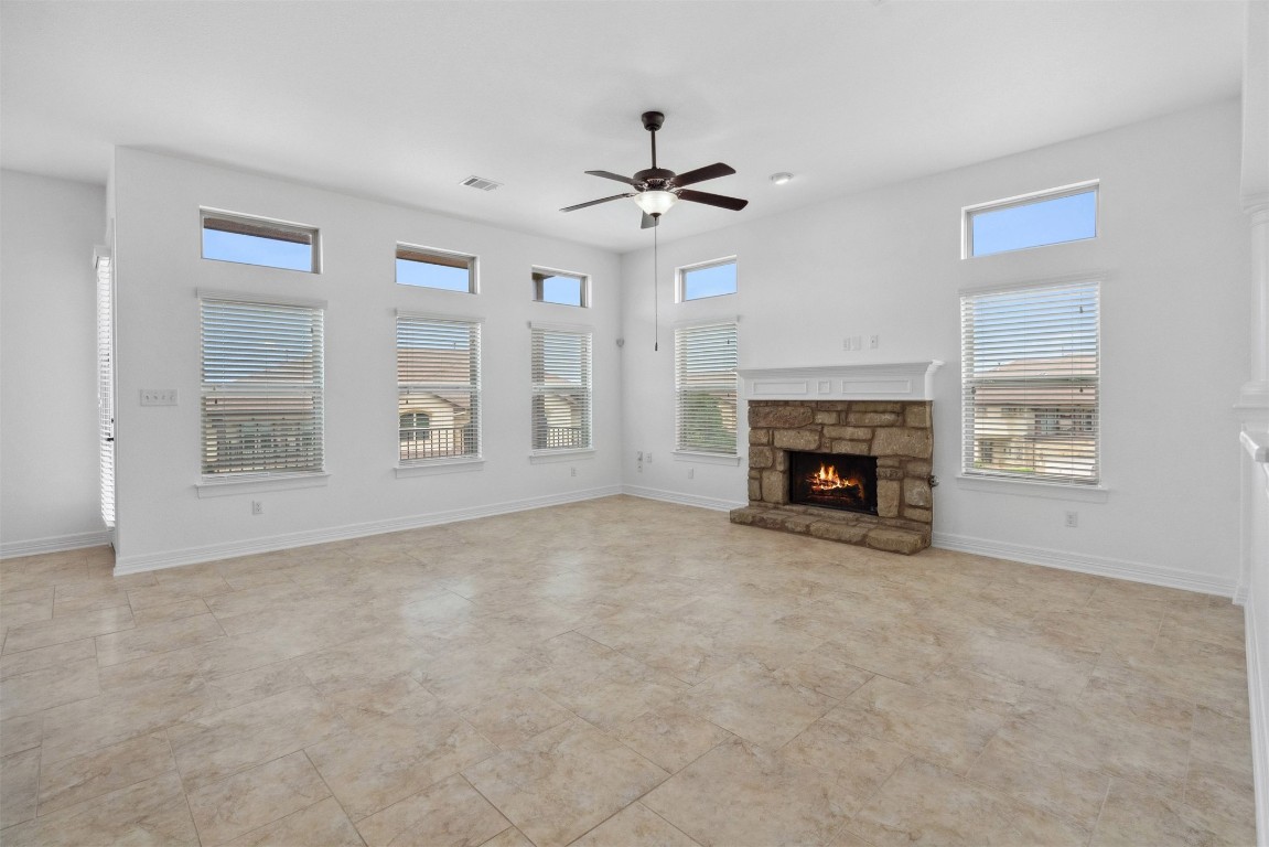 111 ANTONIO Way, Unit 5A Austin, TX 78734 - Photo 11 of 40 an empty room with windows fireplace and fan