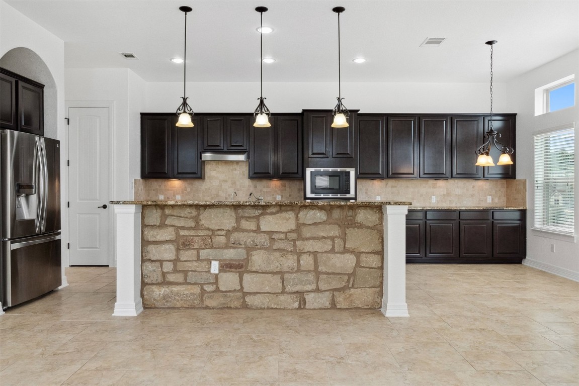111 ANTONIO Way, Unit 5A Austin, TX 78734 - Photo 15 of 40 a kitchen with stainless steel appliances granite countertop a stove a sink and a refrigerator