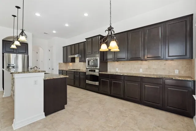 a kitchen with stainless steel appliances granite countertop a stove and a refrigerator