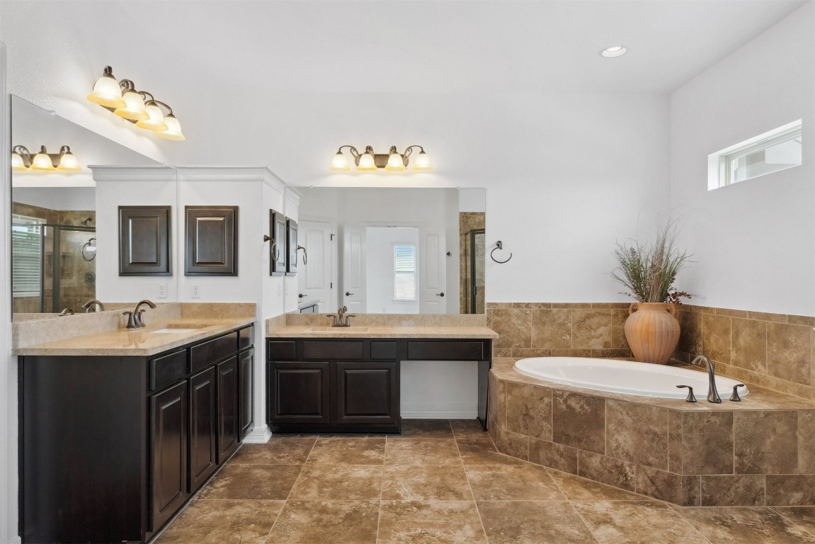 111 ANTONIO Way, Unit 5A Austin, TX 78734 - Photo 25 of 40 a spacious bathroom with a tub double sink and mirror