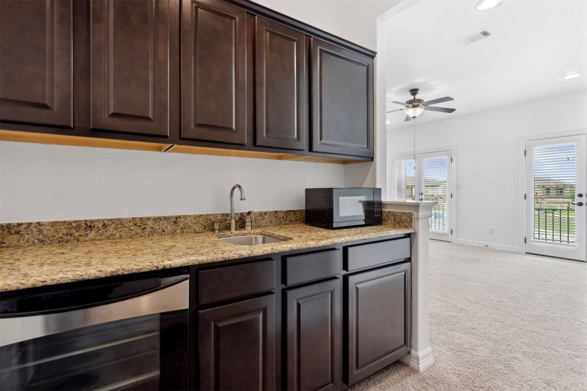 111 ANTONIO Way, Unit 5A Austin, TX 78734 - Photo 30 of 40 a kitchen with stainless steel appliances granite countertop a sink a stove and a microwave oven
