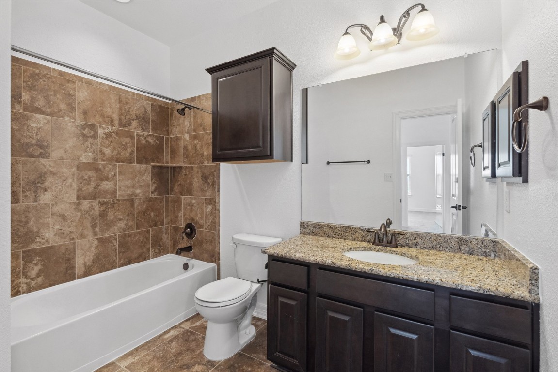 111 ANTONIO Way, Unit 5A Austin, TX 78734 - Photo 32 of 40 a bathroom with a granite countertop sink toilet and shower