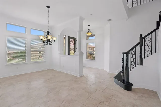 an empty room with windows fireplace and fan