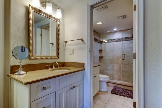 a bathroom with a double vanity sink toilet and shower