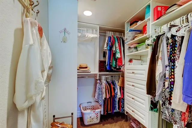 a view of walk in closet with clothes