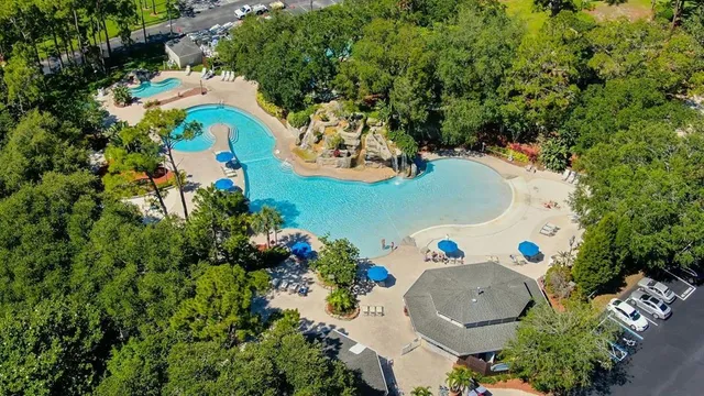 an aerial view of a house with swimming pool and outdoor seating