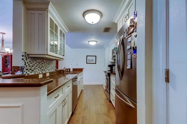 a kitchen with stainless steel appliances granite countertop a refrigerator and a stove