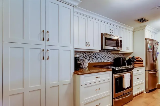 a kitchen with white cabinets and appliances
