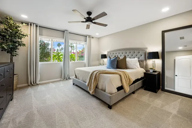 a bedroom with a large bed and a chandelier