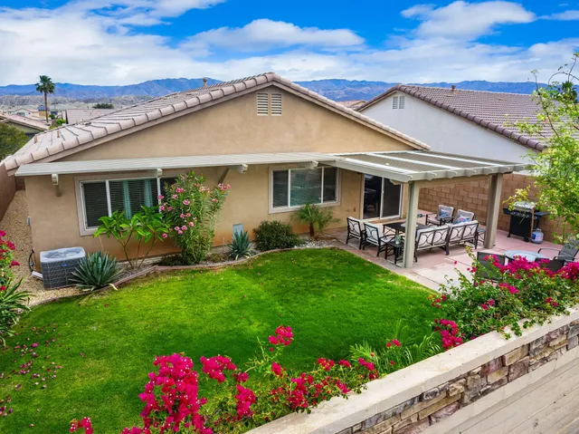 a view of a house with a big yard and potted plants