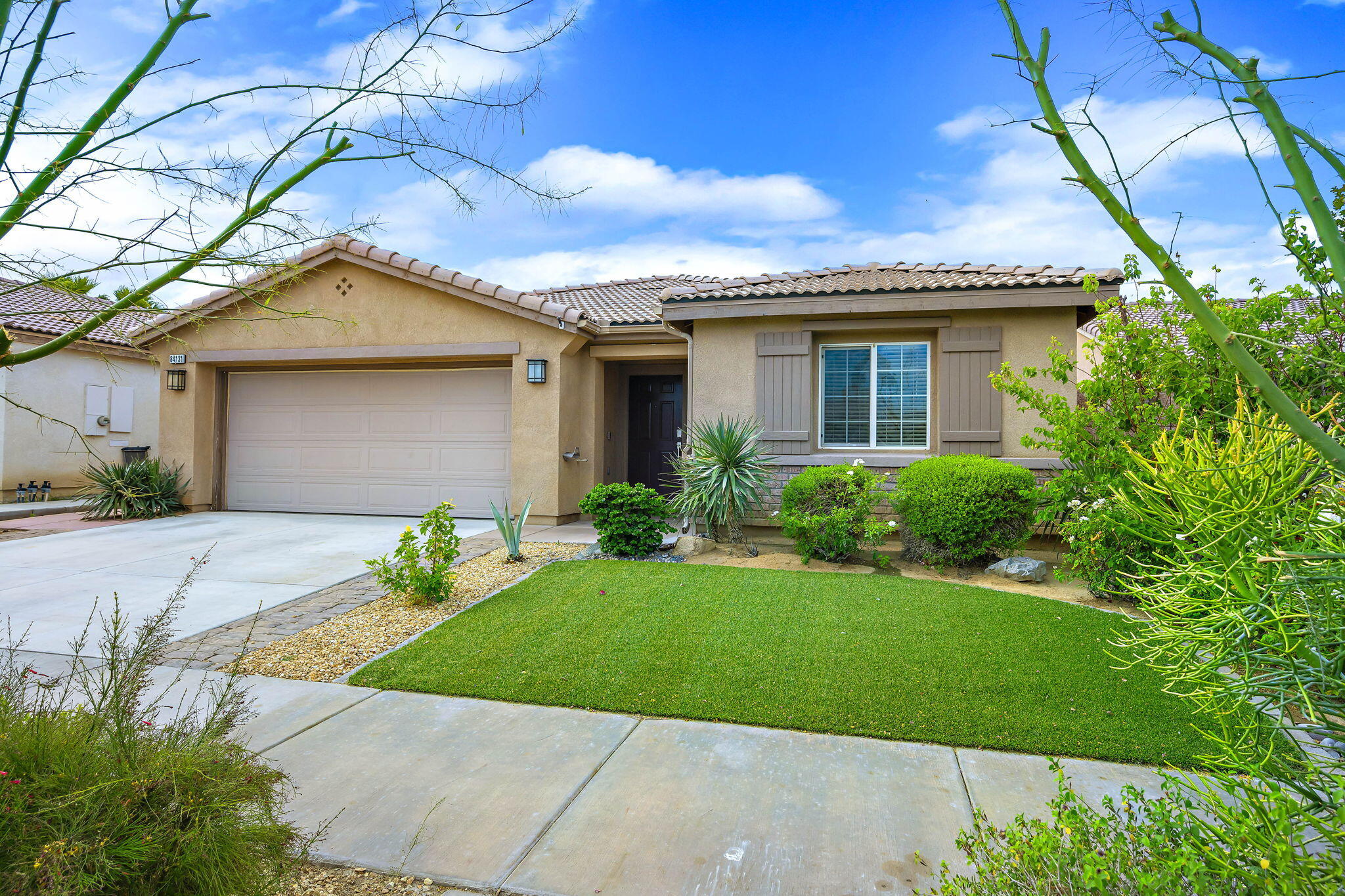 84131 Azzura Way Indio, CA 92203 - Photo 31 of 38 a front view of a house with a garden