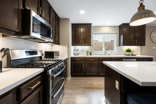 a kitchen with stainless steel appliances a sink cabinets and a stove top oven