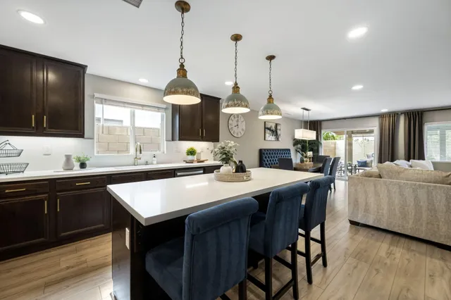 a kitchen with stainless steel appliances granite countertop a kitchen island a stove a table and chairs