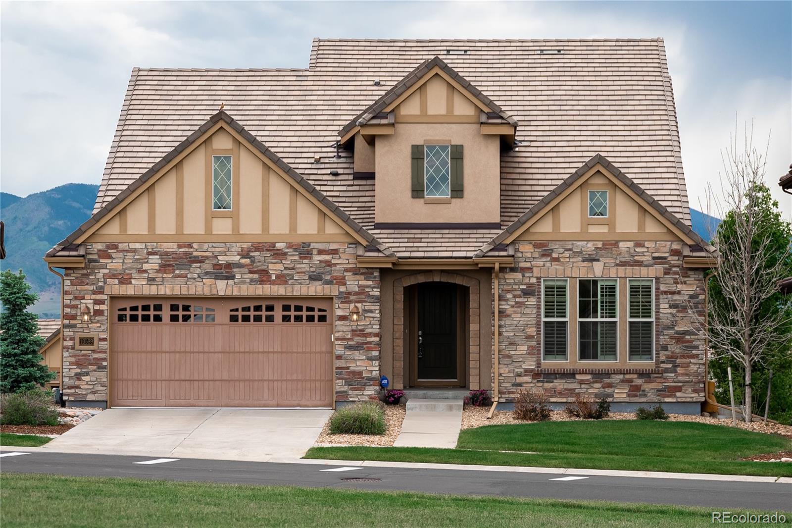 10599 Sundial Rim Road Highlands Ranch, CO 80126 - Photo 1 of 40 a front view of a house with a yard and garage