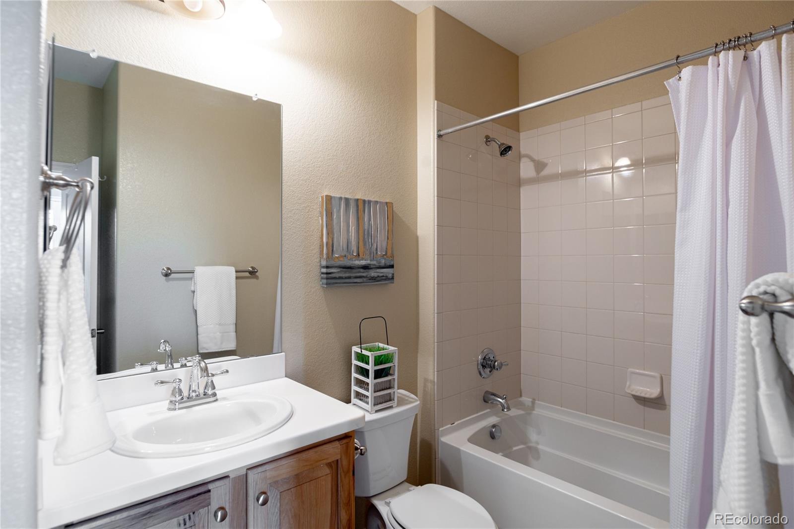 10599 Sundial Rim Road Highlands Ranch, CO 80126 - Photo 15 of 40 a bathroom with a bathtub shower sink vanity and toilet