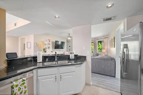 a large living room with stainless steel appliances kitchen island granite countertop furniture and a view of living room