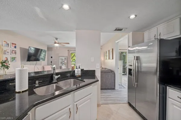 a kitchen with stainless steel appliances granite countertop a sink refrigerator and microwave