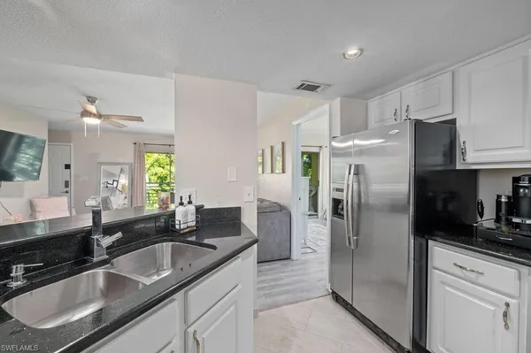 a kitchen with granite countertop a refrigerator and a sink