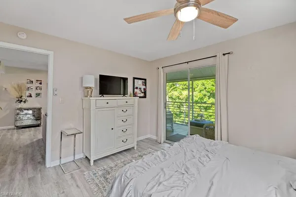 a bedroom with a bed and a flat tv screen on dresser
