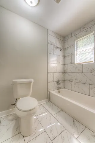 a bathroom with a toilet a sink and bathtub