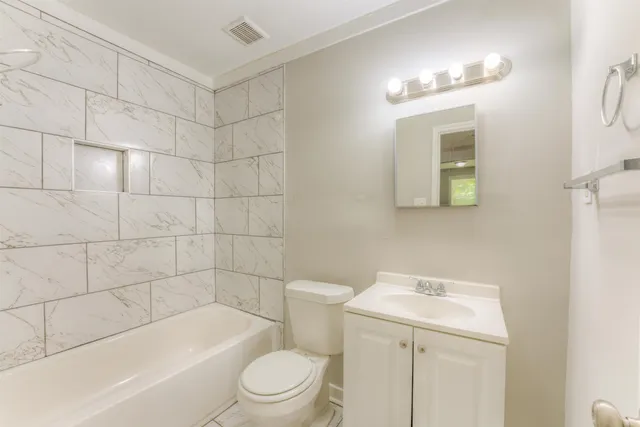 a bathroom with a toilet a sink a mirror a bathtub and shower