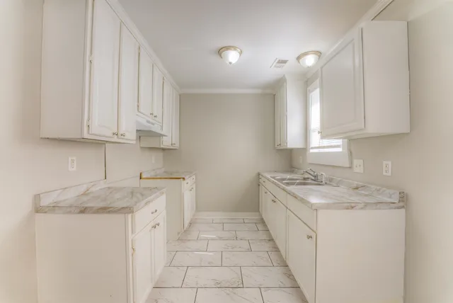 a kitchen with a sink stove and cabinets