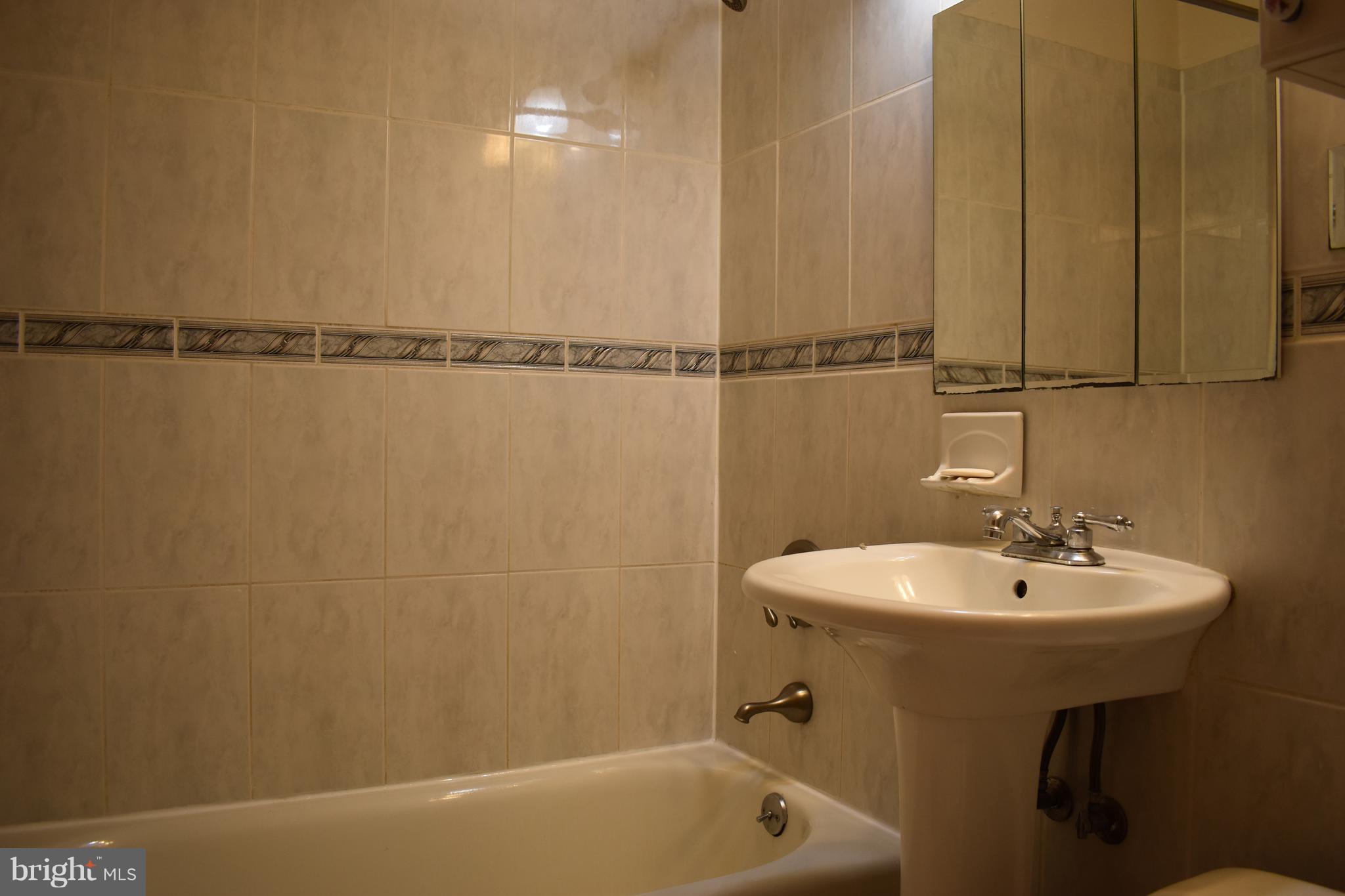 11505 Goodloe Road Silver Spring, MD 20906 - Photo 11 of 25 a bathroom with a sink a mirror and a bathtub