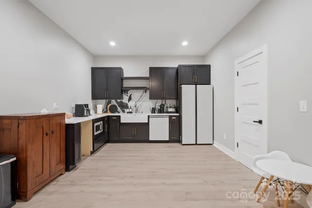 a kitchen with stainless steel appliances kitchen island granite countertop a refrigerator and a sink
